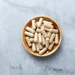 Ashwagandha Capsules on a wooden bowl
